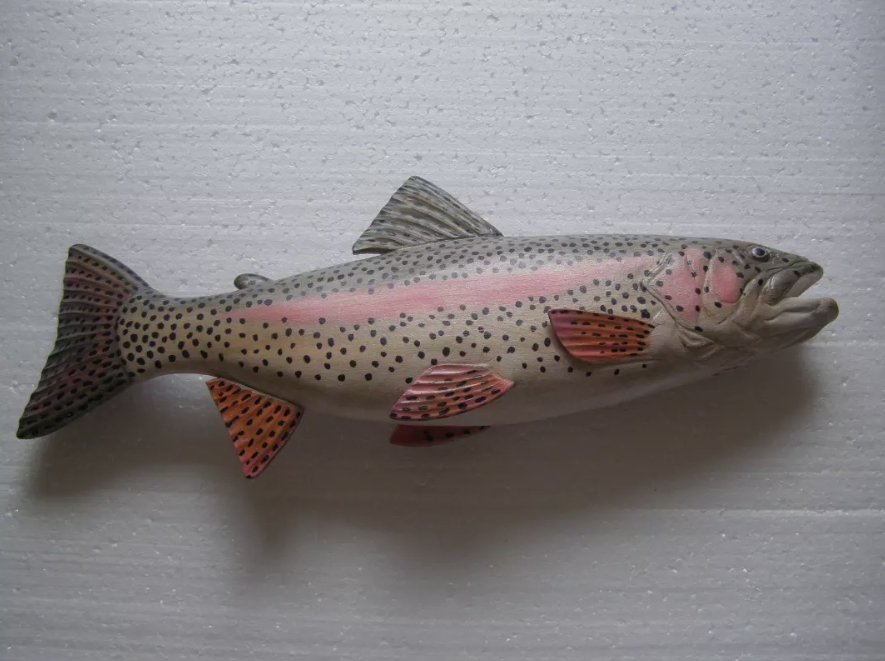 A finished fish carving displayed on a shelf