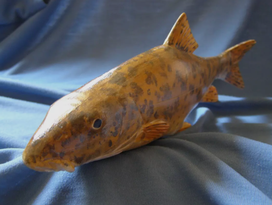 Close-up of carved scales on a wooden fish